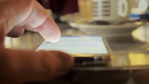 Hand of man runs on a smartphone screen during breakfast Stock Footage 71034755