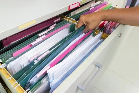 Hand of Man Search files document in a file cabinet in work office 库存照片