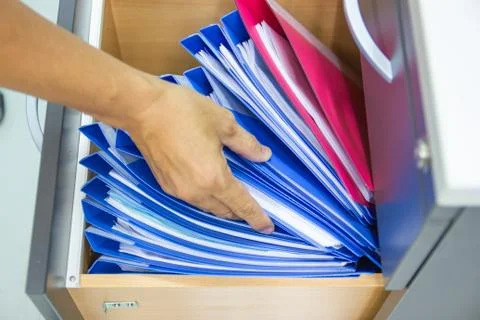 Hand of Man Search files document in a file cabinet in work office Photos