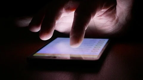 Hand of a man searching on a touch screen smartphone in the dark Video stock 89307957