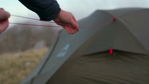The hand of a man setting up a tent Stock Footage 162379996