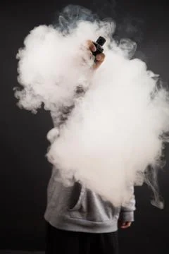 Hand of man soars on the smoke with mod in a black background. Stock Photos
