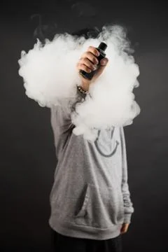 Hand of man soars on the smoke with mod in a black background. Stock Photos