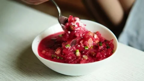 The hand of a man with a spoon takes borscht from the plate.  Stock Footage 282960603