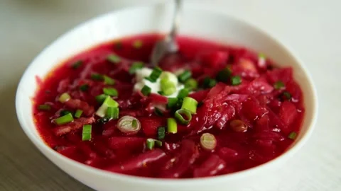 The hand of a man with a spoon takes borscht from the plate.  Stock Footage 282960647