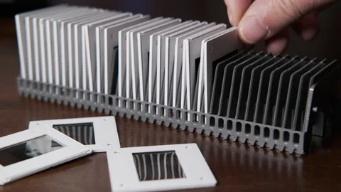 Hand of a man stacking slides in a projector tray vintage products Видео 170251509