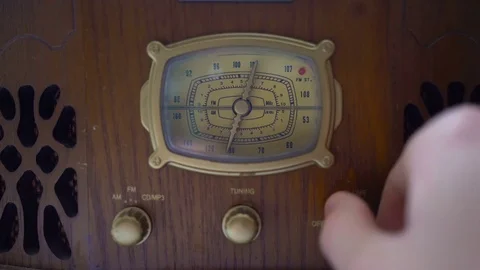 The hand of a man turns the dial on an old vintage radio. Concept: look for good Video stock 73829436