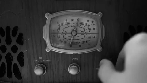 The hand of a man turns the dial on an old vintage radio. Concept: look for good Video stock 73829665