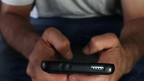 Hand of a man typing a message on the screen of a smart phone Stock Footage 244515039