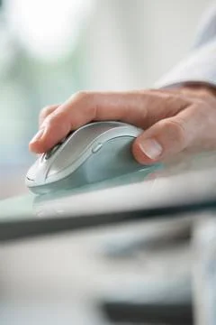 Hand of man using his forefinger to control a cordless mouse Stock Photos