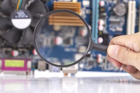 Hand man using Magnifying glass for analyzing computer mainboard, Concept o.. Stock Photos