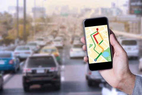 Hand of man using map on smartphone application with traffic jam background. Stock Photos