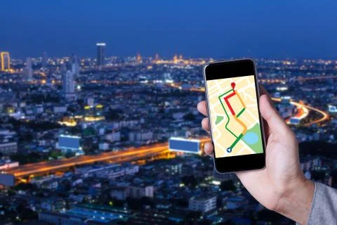 Hand of man using map on smartphone application with cityscape background. Stock Photos