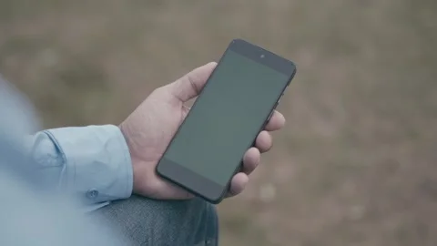 Hand of a man in a  using a mobile phone with green screen markers. Stock Footage 340222308