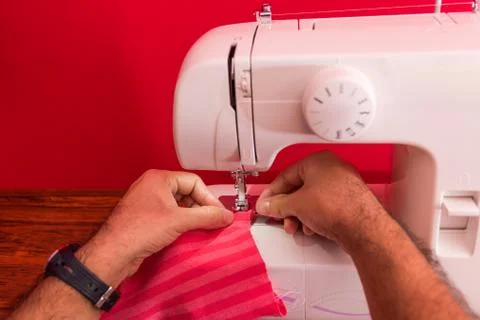 Hand of man using a sewing machine. Concept of National Sewing Machine day, j Stock Photos
