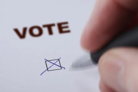 Hand of man voting - sets mark in check box with pen Foto stock