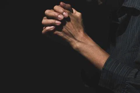 Hand of man while praying for religion. Concept peace and life. Stock Photos
