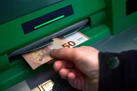 Hand of man while withdrawing banknotes 50 euros from an ATM Stock Photos