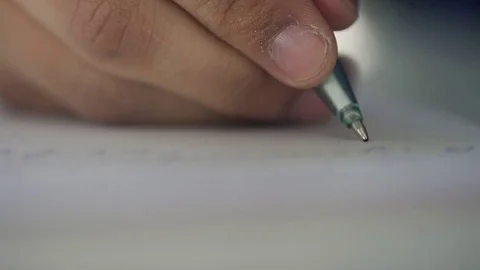 Hand of man writes on white paper with pen indoors. Video stock 77689778