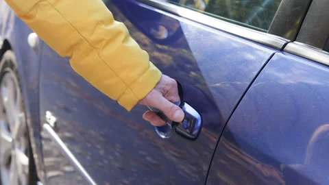 Hand of man in yellow jacket opens the driver's seat door of blue car. Stock Footage 163269258