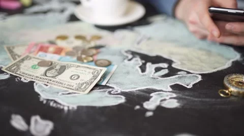 Hand, map, compass, money and phone on the chalkboard table. Stock Footage 61331267