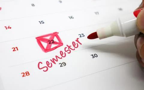 Hand marking a calendar with Semester in red, symbolizing academic planning.. Stock Photos