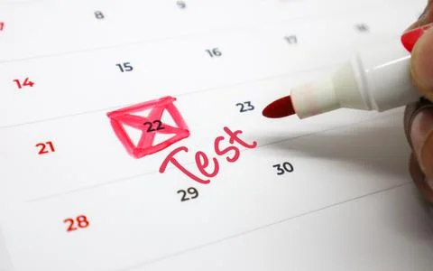 Hand marking Test on a calendar date, highlighting an important upcoming ex.. Stock Photos