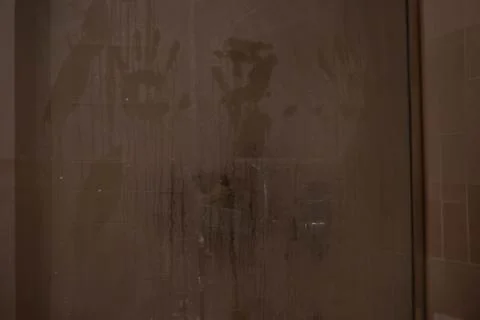 Hand marks on a shower screen wet and fogged by the steam of hot water. Stock Photos