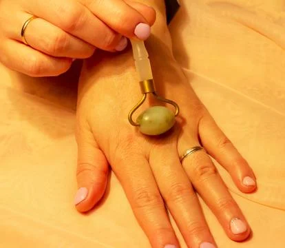 Hand massage with a jade roller Stock Photos