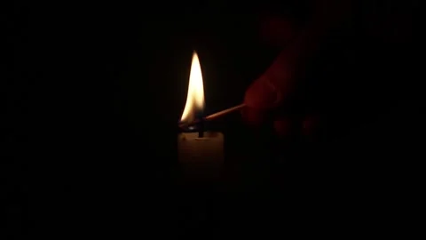 Hand With A Match Lights A Single Wax Candle In The Dark Stock Footage 150666541