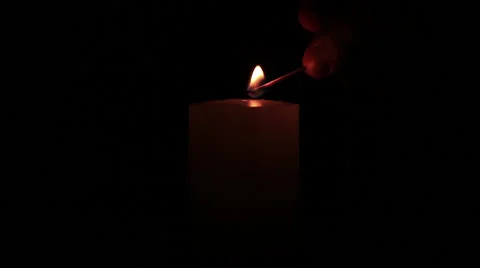 Hand with a matchstick lighting a candle Stock Footage 58310895