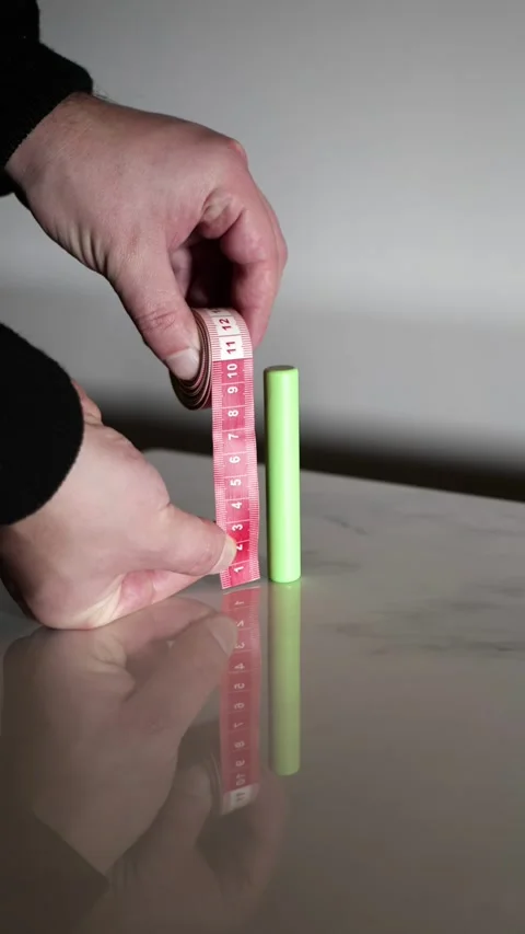 Hand Measuring the Length of a Cylindrical Rechargeable Battery Video stock 325629432