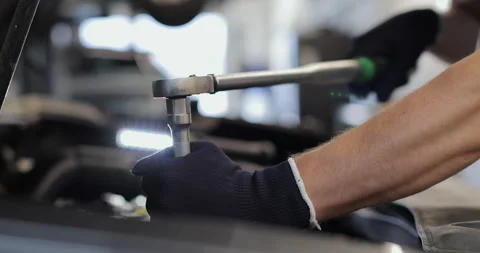 Hand of mechanic man using socket spanner wrench repairing a car in workshop Stock Footage 341863660