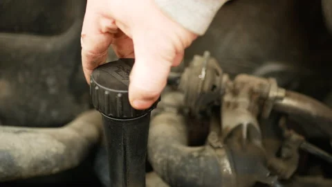 Hand of a mechanic repairman adding or pouring oil to the old car engine. Stock Footage 163266604