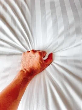 Hand of men pulling white sheets in ecstasy, orgasm. Stock Photos