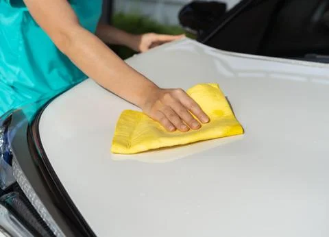Hand with microfiber cloth cleaning car roof Stock Photos