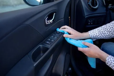 Hand with a microfibre cloth cleans the interior of the car Stock Photos