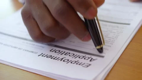 Hand of migrant ticking on the sheet while filling out job application Video stock 231678820