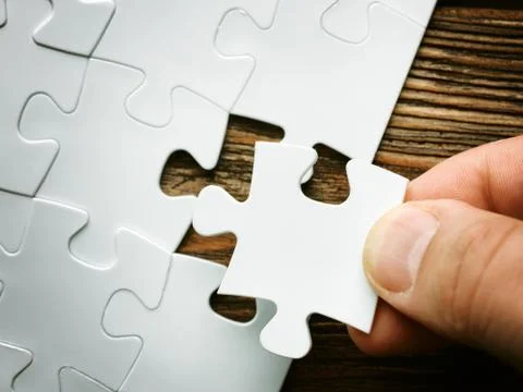 Hand with missing jigsaw puzzle piece. Business concept image for completing 写真素材