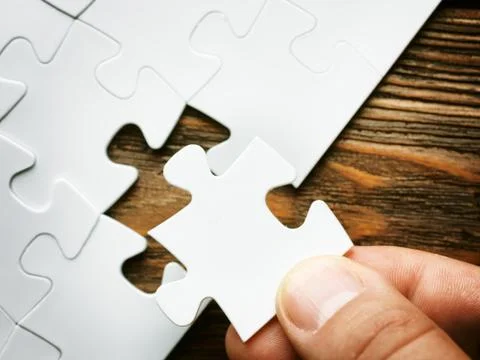 Hand with missing jigsaw puzzle piece. Business concept image for completing Stock Photos