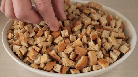 Hand mixing bread croutons in a white bowl. Stock Footage 327113707