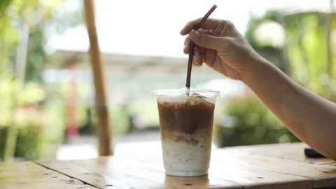 Hand mixing coffee with milk Stock Footage 119694620