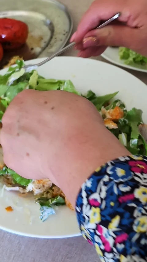 Hand mixing fresh caesar salad on white plate with roasted tomatoes on Stock Footage 336965449