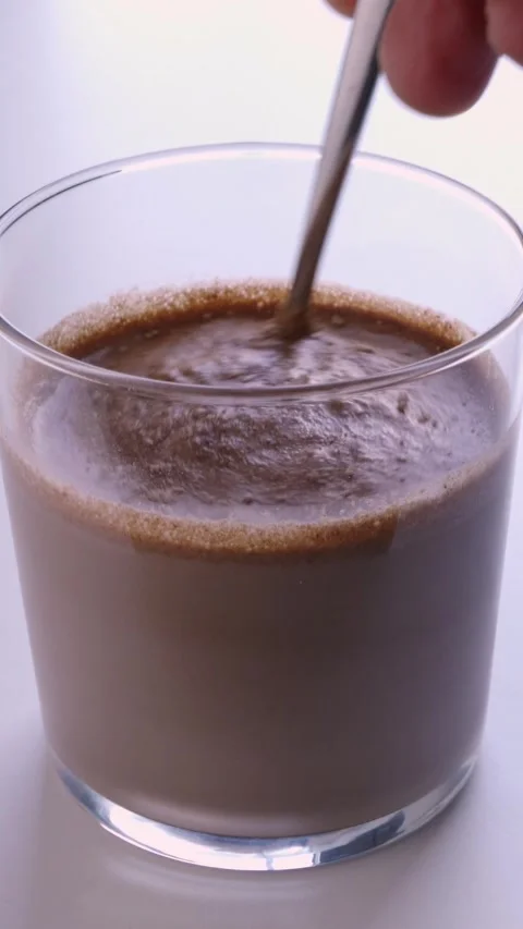 Hand mixing with scoop of chocolate 库存影片 337033237