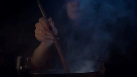 Hand mixing with spoon something in steaming cauldron Stock Footage 141293658
