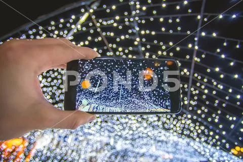 The hand with mobile camera shot bright garland Stock Photos