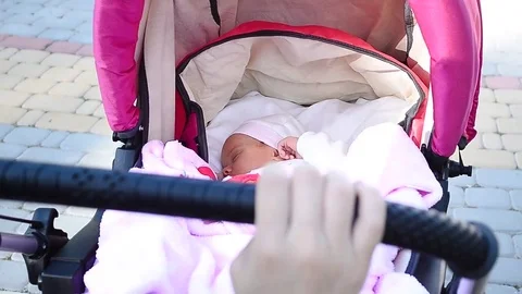 Hand mother rolls stroller with sleeping baby Stock Footage 76257138