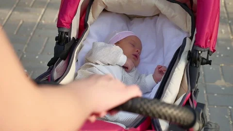 Hand mother rolls stroller with sleeping baby Stock Footage 76520695