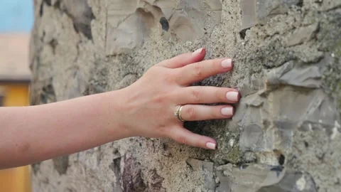 The hand moves along an old stone wall. Sliding. Surface made of hard stone. Stock Footage 327797239