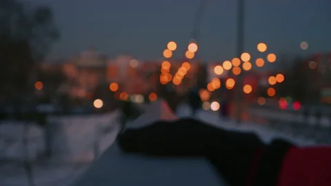 Hand moves away camera with blurred city background at sunset Stock Footage 151475088